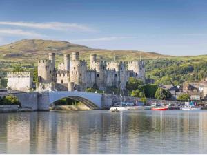 a castle on a bridge over a body of water at Ffynonn Wen in Llandrillo-yn-Rhôs