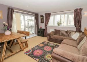 a living room with a couch and a table at Ffynonn Wen in Llandrillo-yn-Rhôs