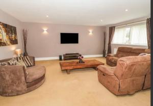 a living room with two couches and a coffee table at Ffynonn Wen in Llandrillo-yn-Rhôs