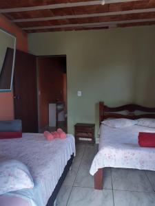 una camera con due letti con cuscini rosa di Casa Pôr do Sol a São Thomé das Letras
