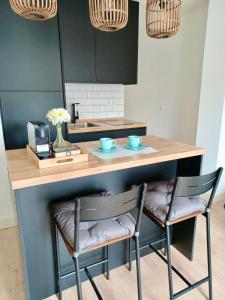 a kitchen with a counter with two chairs at a kitchen island at La Plaza Apartamento Armilla in Armilla