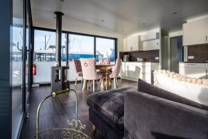 a living room with a couch and a table with chairs at Schwimmendes Haus - Hausboot Paradise in Peenemünde