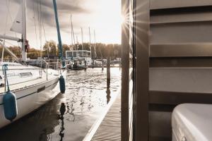 un barco está atracado en un muelle en el agua en Schwimmendes Haus - Hausboot Paradise en Peenemünde