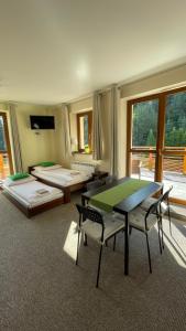 a room with two beds and a table and chairs at Górskie Zacisze in Zawoja
