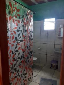 e bagno con tenda per la doccia, servizi igienici e lavandino. di Casa Pôr do Sol a São Thomé das Letras