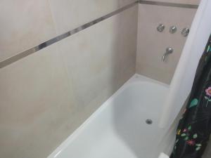 Un baño con ducha con cortina de ducha. en El Serrano, en Tandil