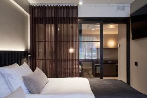 カヤーニにあるOriginal Sokos Hotel Valjus Kajaaniのベッドルーム1室(白いベッド1台、ガラスのスライドドア付)