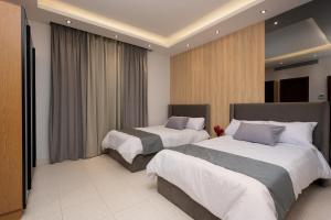 Habitación de hotel con 2 camas y cortinas en Kattameya dunes 4 master bedrooms villa en El Cairo
