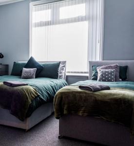 1 Schlafzimmer mit 2 Betten und einem Fenster in der Unterkunft Modern 5 Bed Near LFC Stadium in Liverpool