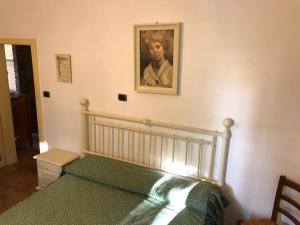 a bedroom with a bed with a painting on the wall at VACANZE A SESTOLA in Sestola