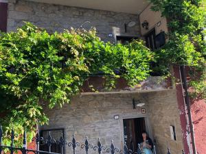 a person sitting in front of a building with plants at VACANZE A SESTOLA in Sestola