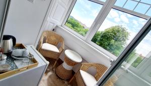 a room with a table and chairs and two windows at Penzion Valkoun-Lilienfeld in Karlovy Vary