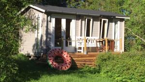 een klein huis met een groot wiel ervoor bij Lohja cottage in Lohja