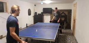 two men standing next to a ping pong table at Apartamenty Koniaków in Koniaków