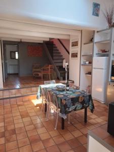 a kitchen with a table and chairs and a staircase at Maison de charme avec vue sur la vallee de la Ceze in Saint-Gervais