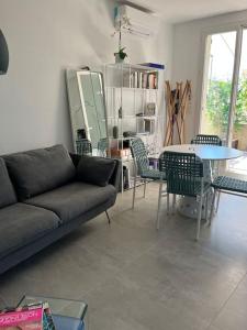 salon z kanapą, stołem i krzesłami w obiekcie La Felicita Aix Centre avec jardin et piscine (de saison) w Aix-en-Provence