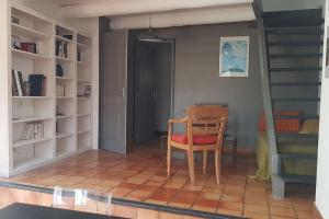 a room with a table and a chair and stairs at Maison de charme avec vue sur la vallee de la Ceze in Saint-Gervais