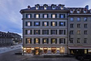 un gran edificio con muchas ventanas en una calle en Stay KooooK Bern City - Online Check In, en Berna