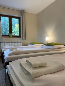 a row of beds in a room with towels on them at Górskie Zacisze in Zawoja