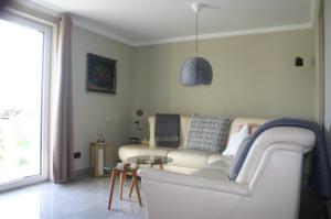 a living room with a white couch and a table at Quartier78 in Mittweida