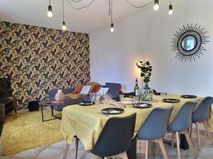 une salle à manger avec une table et des chaises bleues dans l'établissement Gite de la rivière avec patio et parking centre ville, au Mans