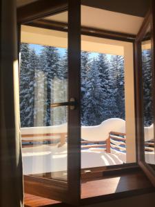 a window with a view of snow covered trees at Górskie Zacisze in Zawoja