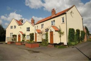 a row of white houses with red roofs at Two Bed First Floor Apartment in Village location in Grantham