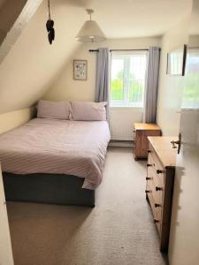 een slaapkamer met een groot bed en een raam bij Two Bed First Floor Apartment in Village location in Grantham