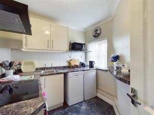 a kitchen with white cabinets and a sink at Two Bed First Floor Apartment in Village location in Grantham