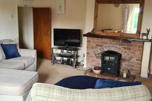 een woonkamer met een open haard en een televisie bij Two Bed First Floor Apartment in Village location in Grantham