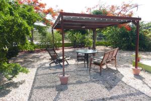 a patio with a table and chairs under a canopy at Resident Emiterio in Blue Bay