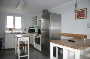 a kitchen with a stainless steel refrigerator and a table at Quartier78 in Mittweida