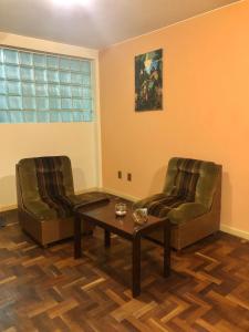 two chairs and a coffee table in a living room at Céntrico apartamento in La Paz