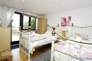 a bedroom with two beds and a window at CROYDE ILUKA 3 Bedrooms in Croyde