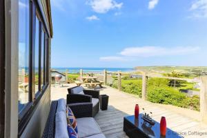 a balcony with furniture and a view of the ocean at CROYDE ILUKA 3 Bedrooms in Croyde
