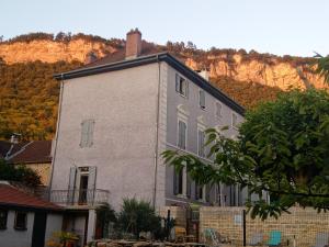 una casa blanca con una montaña en el fondo en A deux pas du Rheby, en Villebois