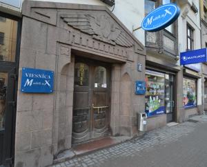 a stone building with a door on a street at Hotel Multilux with Self Check-in in Rīga