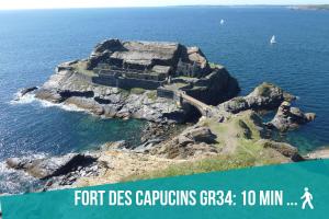 an island in the ocean with a person walking on it at Authentique Penty au coeur du bourg in Roscanvel