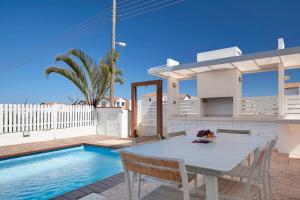 a villa with a swimming pool and a table and chairs at Velomar Villa in Paralimni