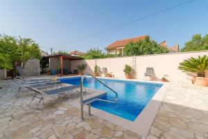 - une piscine dans une cour avec une maison dans l'établissement Apartments Villa Odesa with shared pool, à Zadar