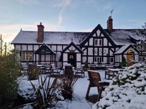 an old black and white building in the snow at White Lion Hotel in Crewe