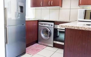 cocina con lavavajillas y lavadora en Stunning 2 Bedroom Inverter , WiFi Inside Golf Estate en Northriding