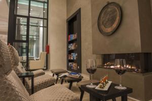 哈馬馬特的住宿－巴迪拉成人酒店，客厅设有壁炉和2杯葡萄酒