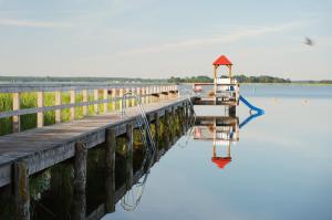 a dock on a body of water with a small boat at Lütt Wieck App Nr 12 in Wieck