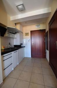 cocina con armarios blancos y puerta marrón en APARTAMENTY TR 11 Apartament nr 1, en Olsztyn
