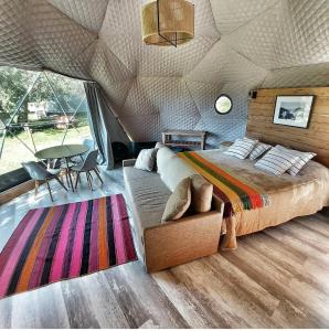 um quarto numa tenda com uma cama e uma mesa em Glamping Vulcanche em Villa Traful