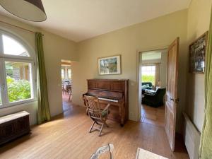 salon z pianinem w pokoju w obiekcie Le colombier, villa vue mer accès plage 300M w mieście Varengeville-sur-Mer