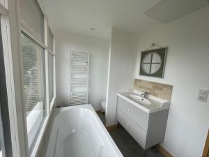 biała łazienka z wanną i umywalką w obiekcie Le colombier, villa vue mer accès plage 300M w mieście Varengeville-sur-Mer