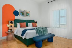 a bedroom with a green bed with orange accents at Neighbourgood Hill in Green Point