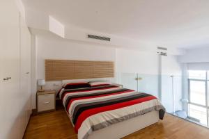 um quarto com uma cama grande num quarto branco em Duplex LOFT Apartamento con Parking GRATIS em Valência